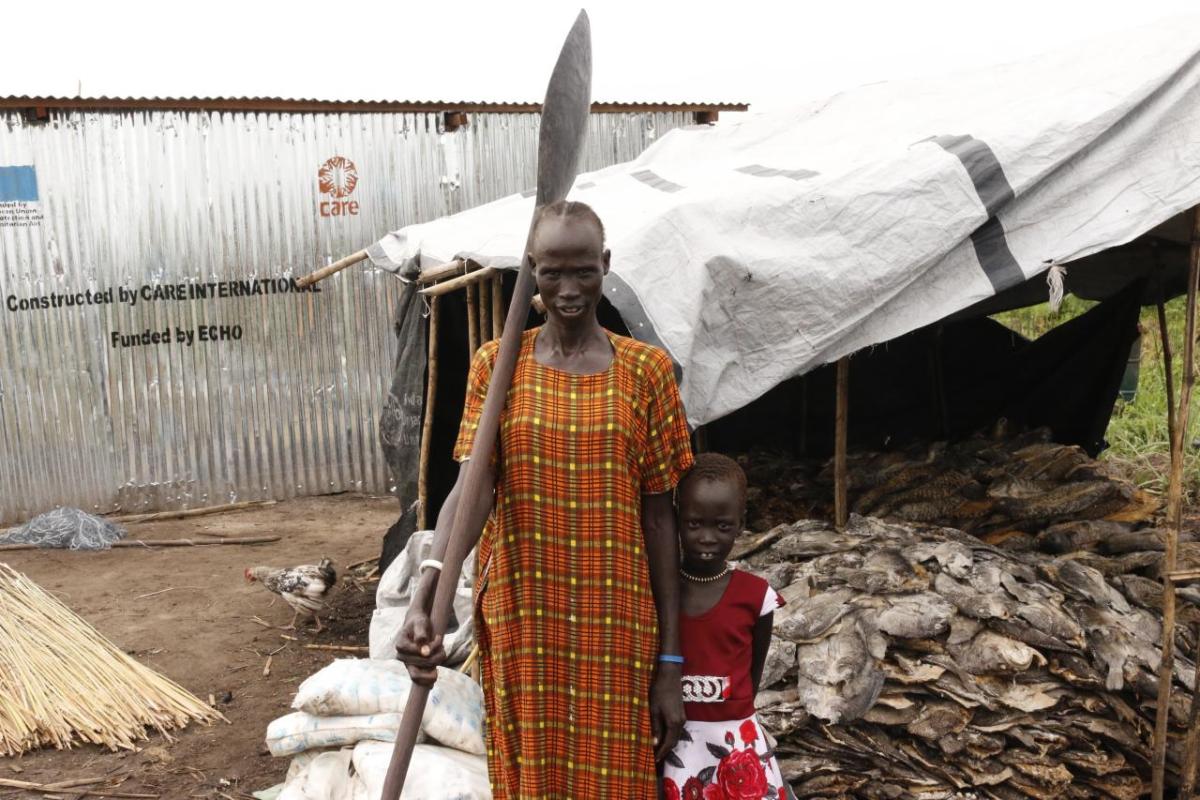 A woman and her child in front of a fish shop in rural Sudan