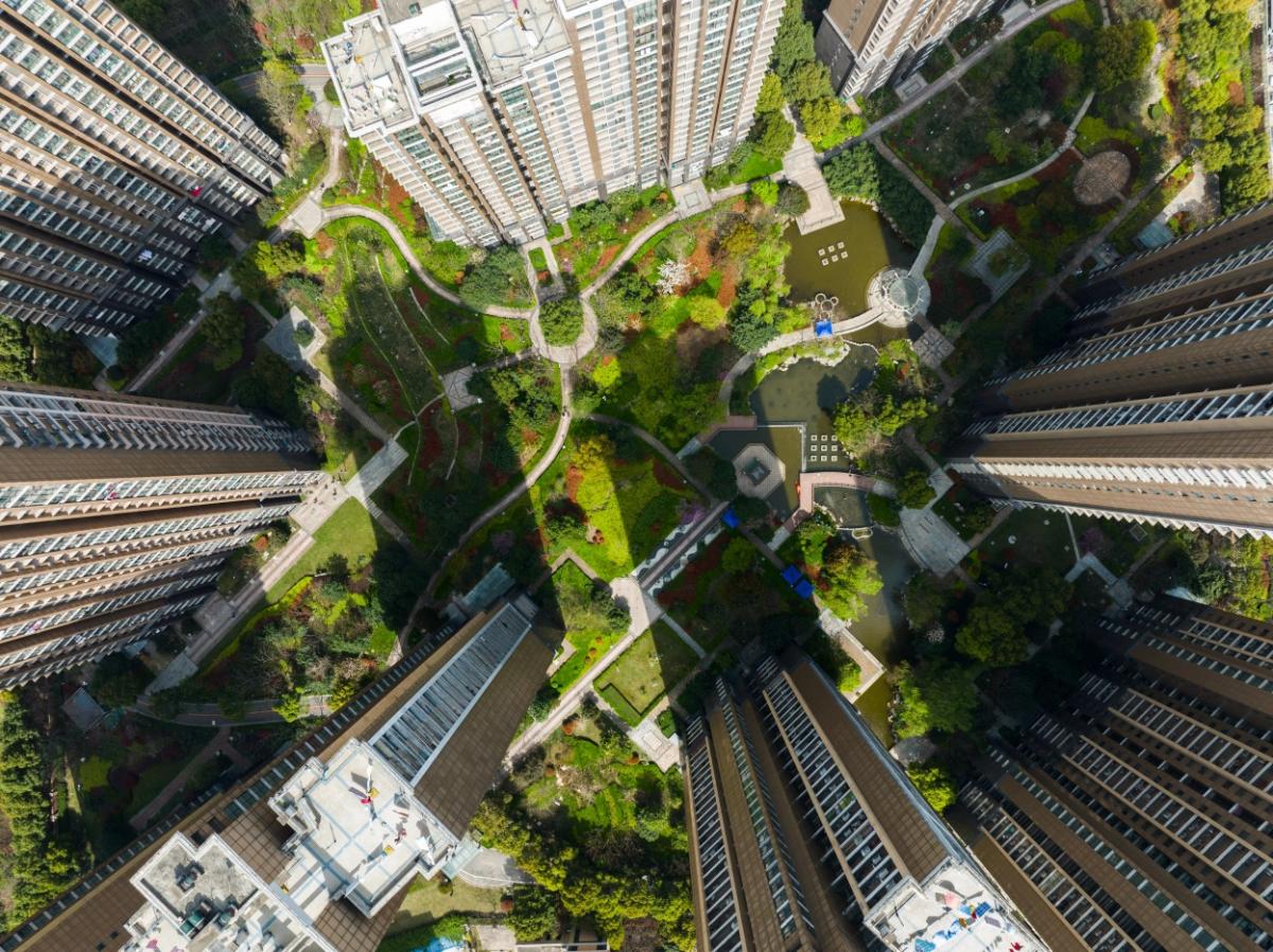 aerial view of a green courtyard in between skyscrapers