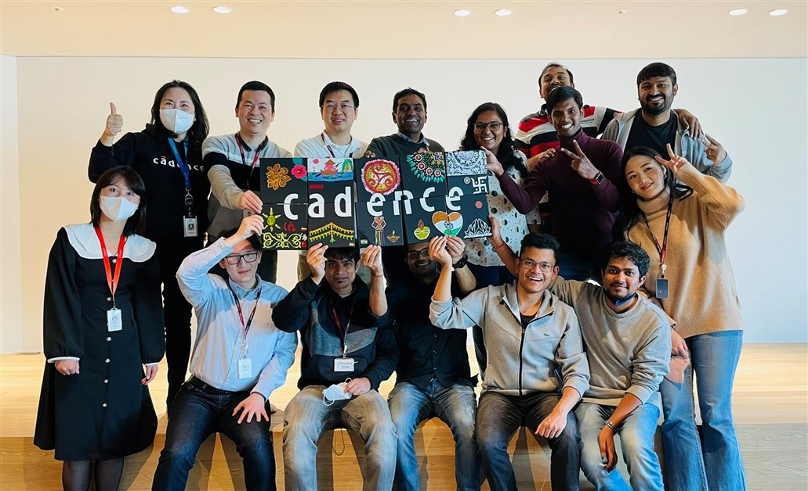 A group of employees holding up a Cadence sign