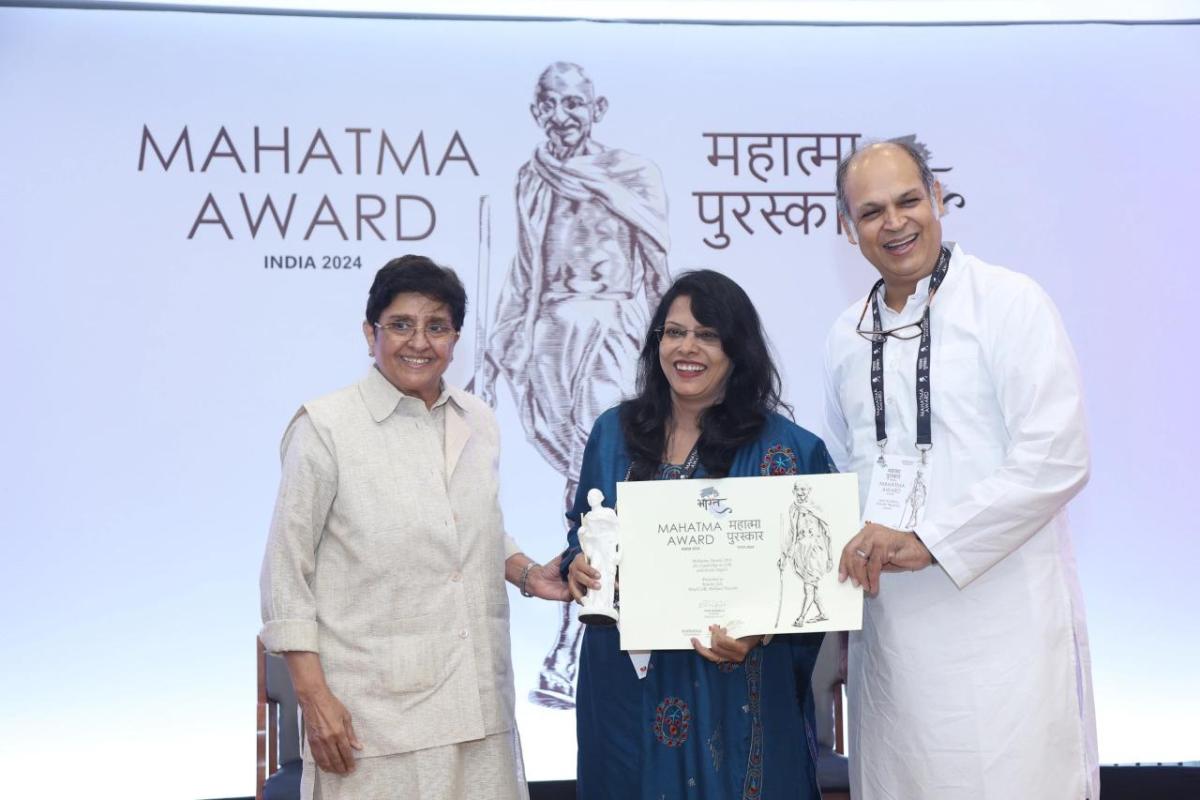 Kavita Sah and two others holding an award.