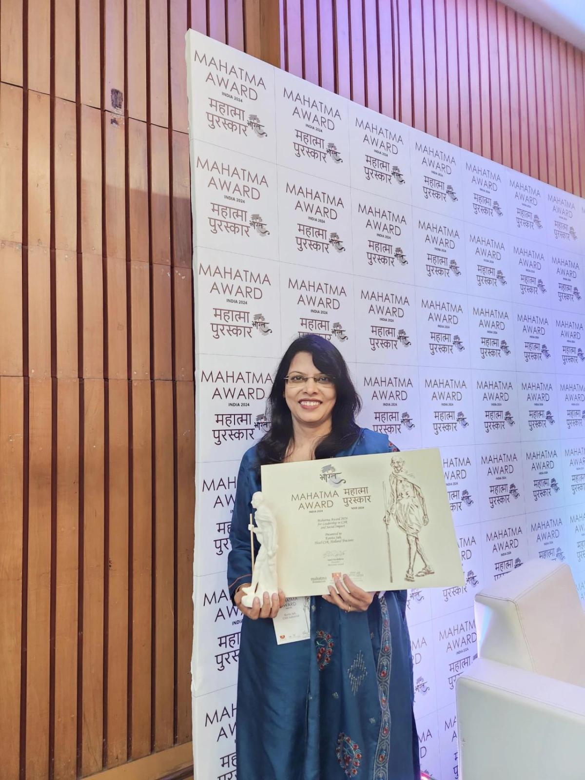 Kavita Sah Holding the Mahatma Award.