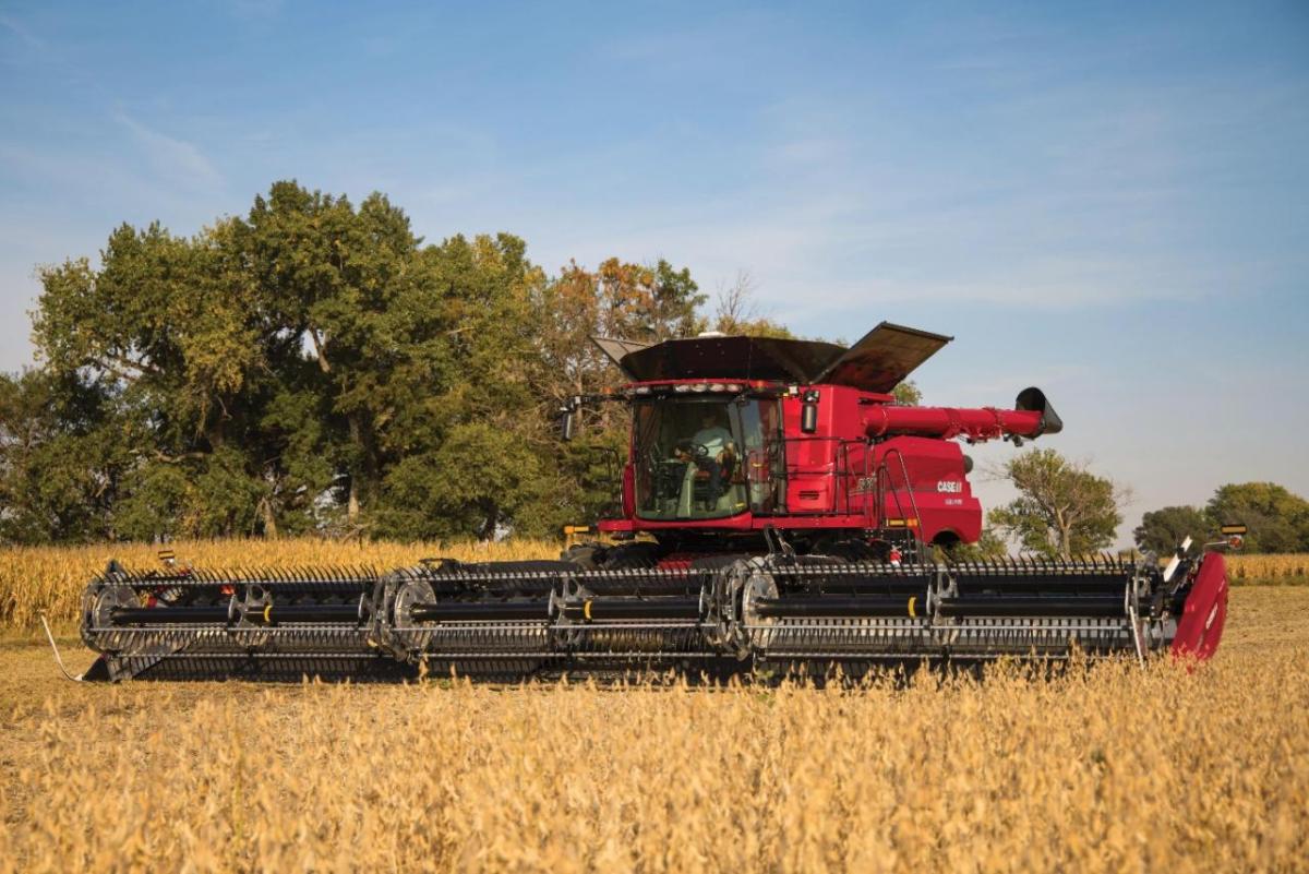 A large red farm harvester in a field