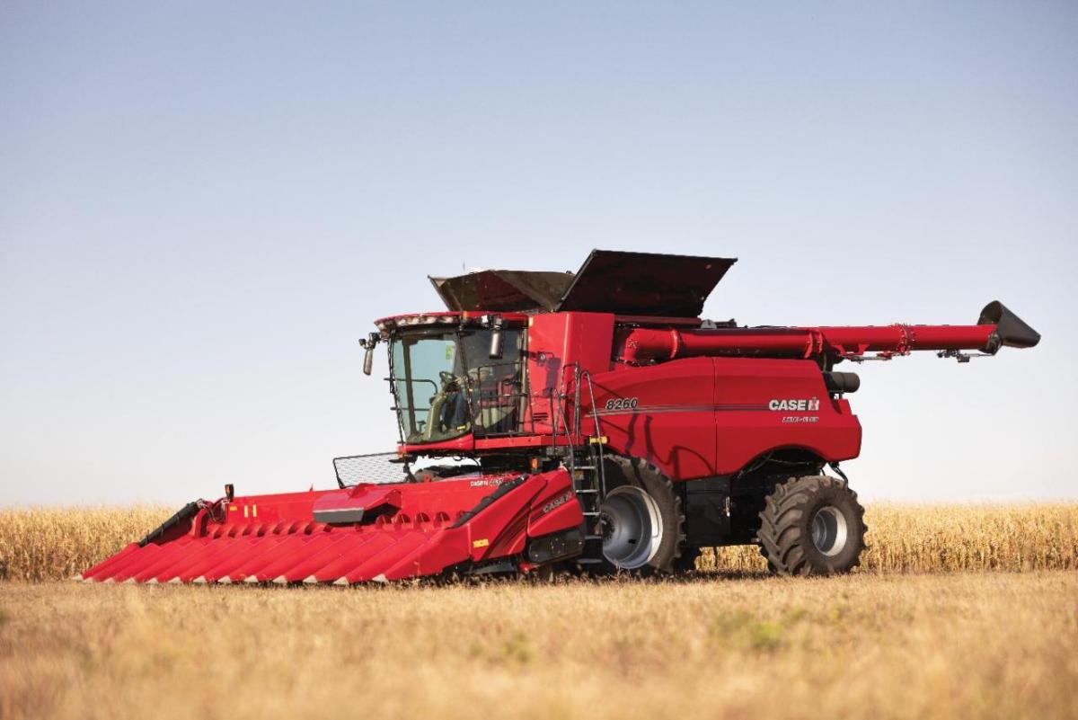 A large red farm harvester in a field