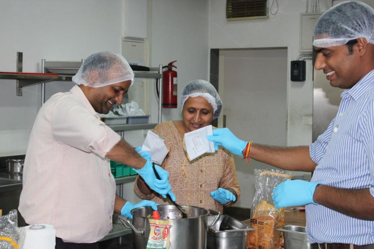 Three people cooking in a kitchen.