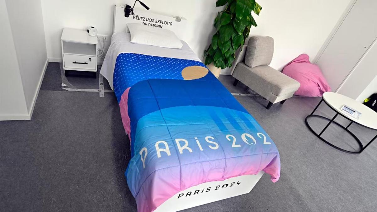 A bedroom scene with a "Paris 2024" comforter on the bed.