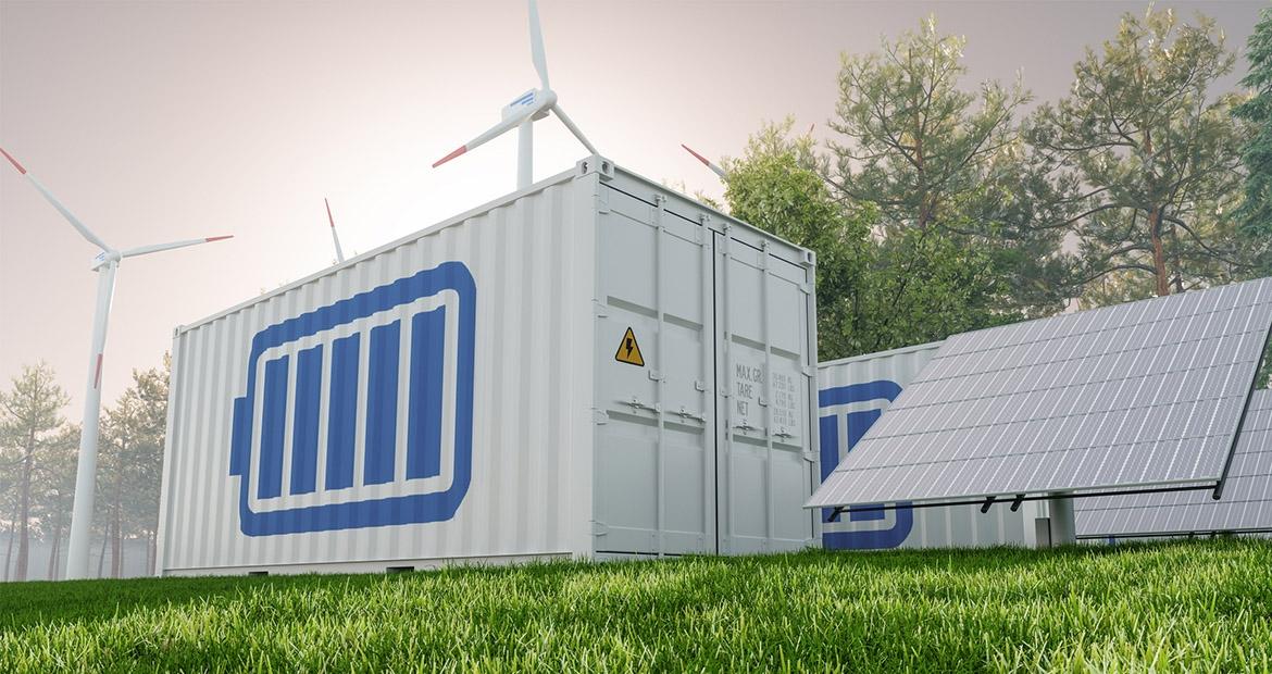 A storage container with a battery symbol on the side, outside next to solar panels and wind turbines.