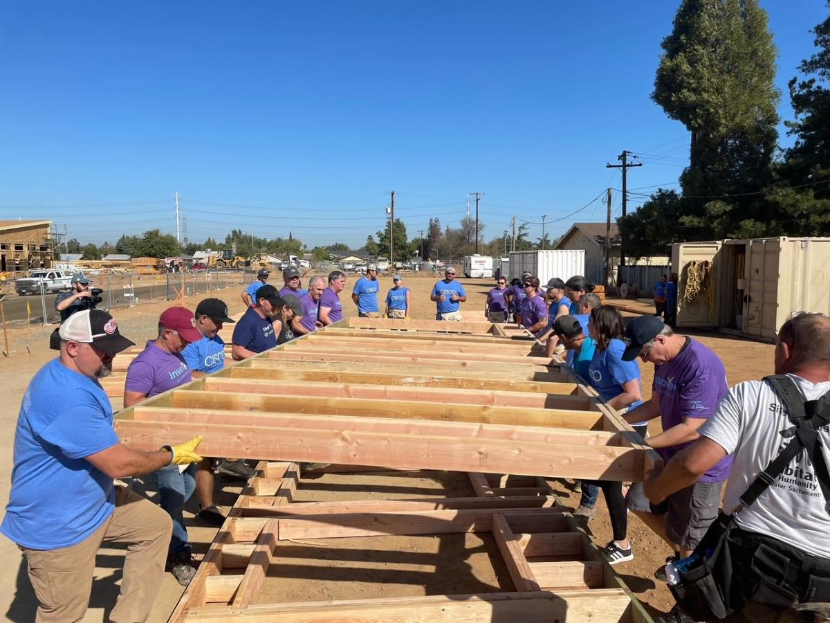 Volunteers putting up a side of a house