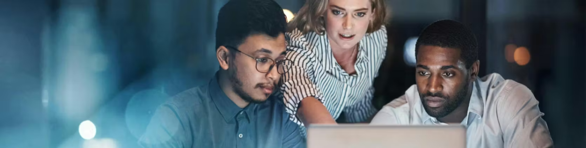 Three people looking at a laptop screen