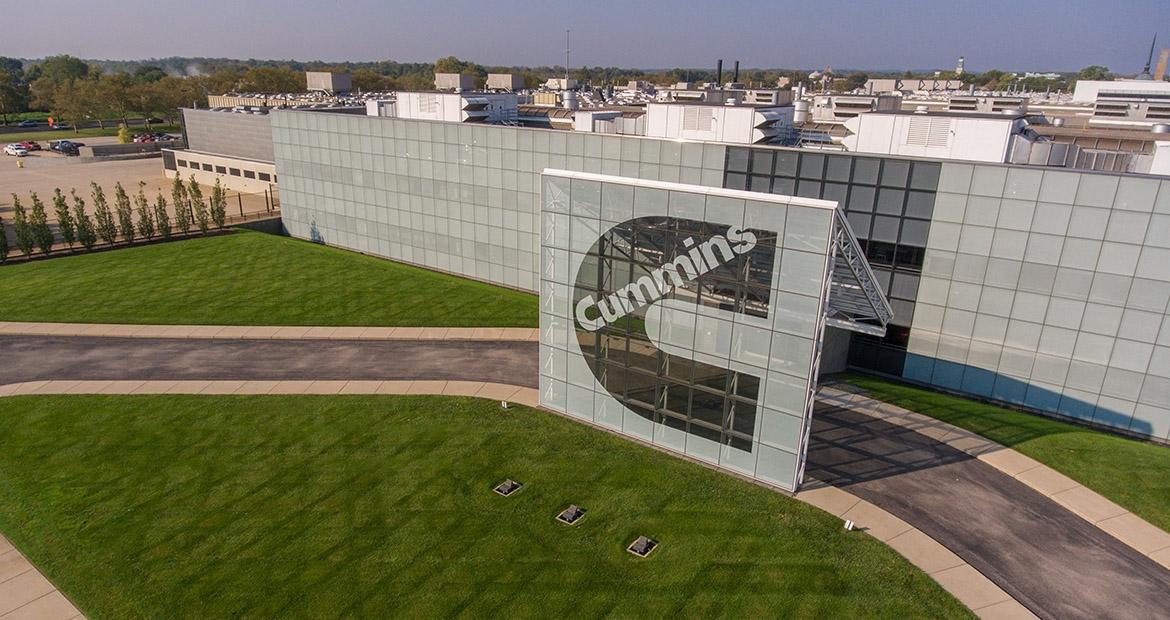 Exterior of a large building with a Cummins sign in front.