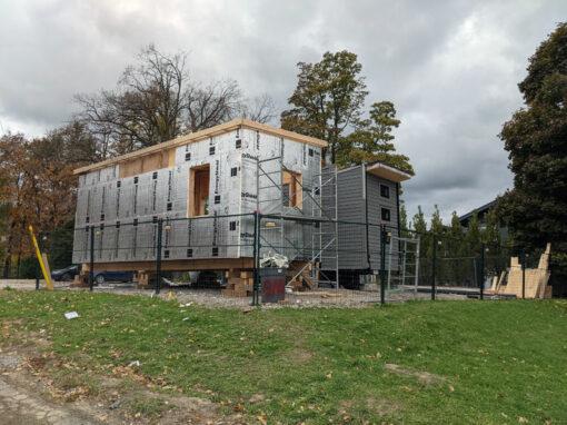 a tiny home being built, insulation exposed, scaffolding outside