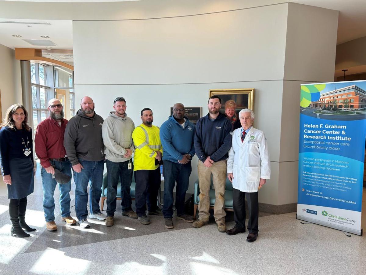 A group posed in the medical center with a doctor.