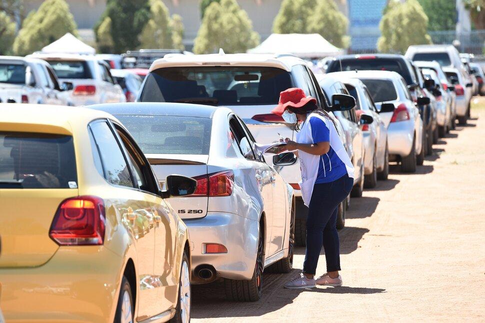 cars parked with person speaking to people in cars