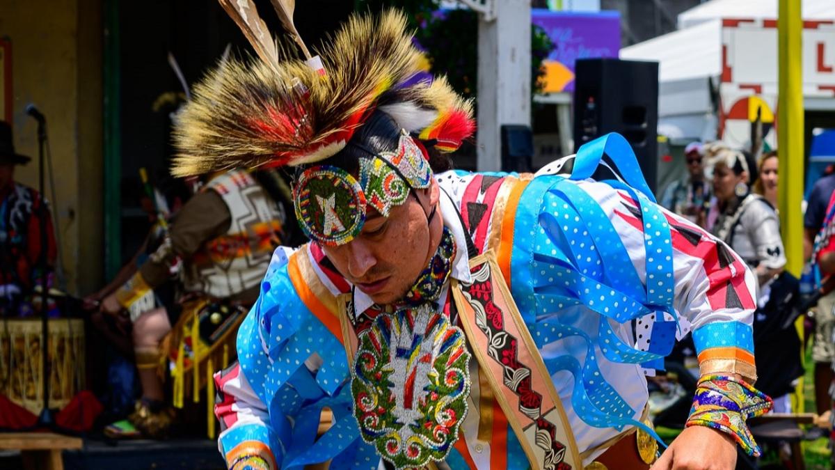 A person in ceremonial garments dancing.