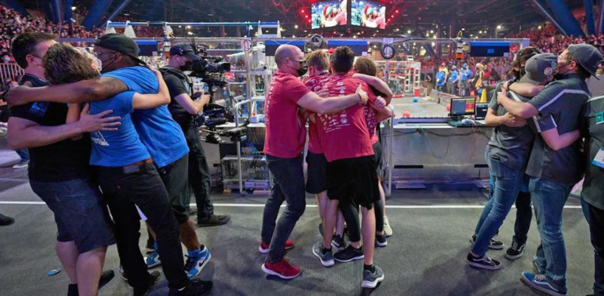 teams in different color shirts hugging