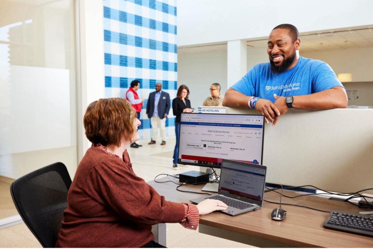 2 employees chat at a desk