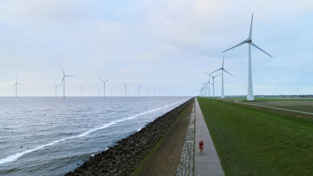 a bike path with windmills in the background
