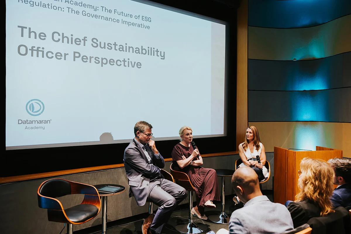 Three people seated in front of others. A large display behind them "The Chief Sustainability Officer Perspective".