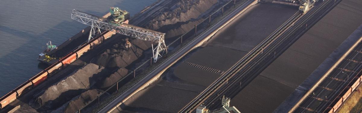 aerial view of huge transport barges being filled with possibly coal. 