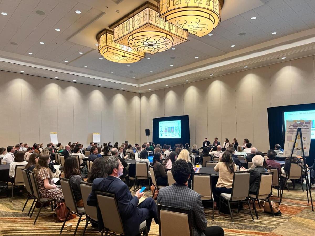 Conference room filled with people at tables and chairs