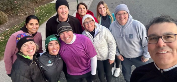 A group posed, taking a selfie outside.