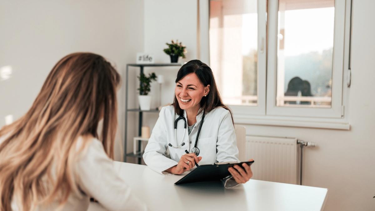 doctor sitting across a table from a patient in a medical office