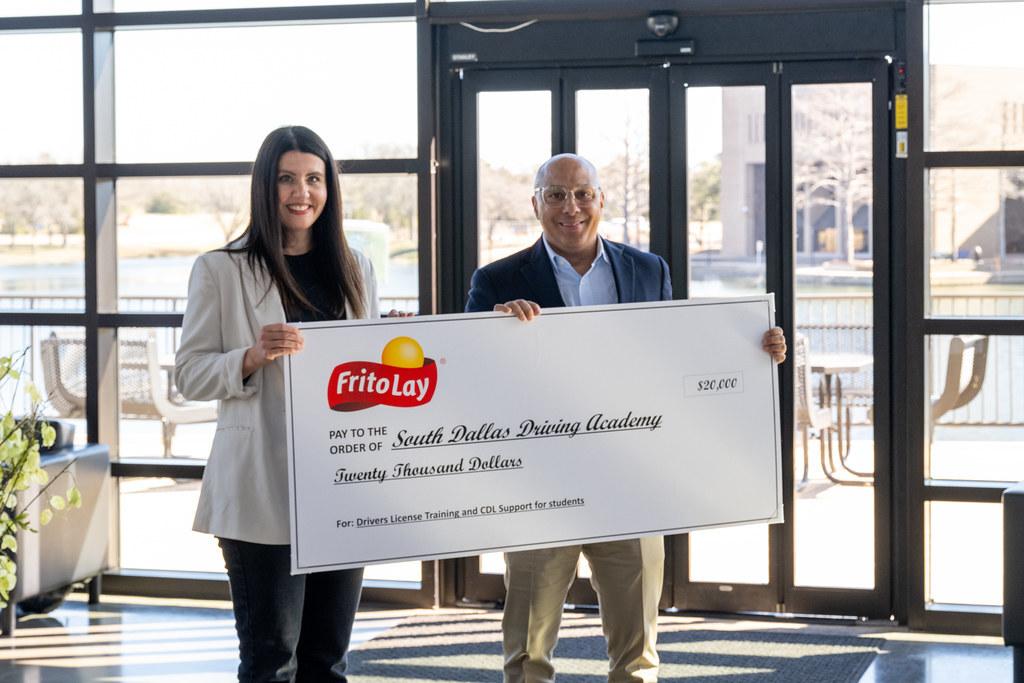 Two people holding a large check