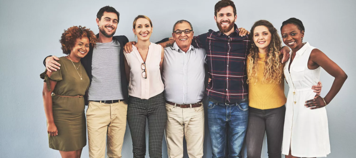 A group of people with their arms over each others' shoulders.