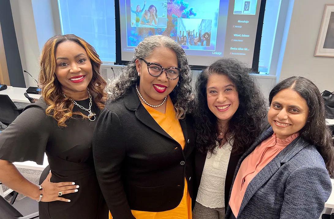 a group of four women in a conference room