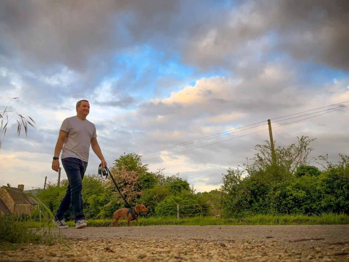 A person walking a dog outside.