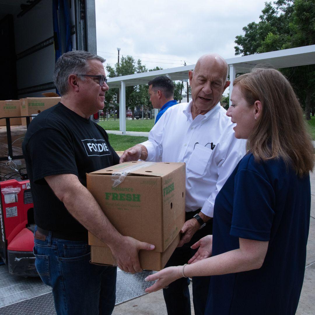 Volunteers handing boxes to each other from off a truck.