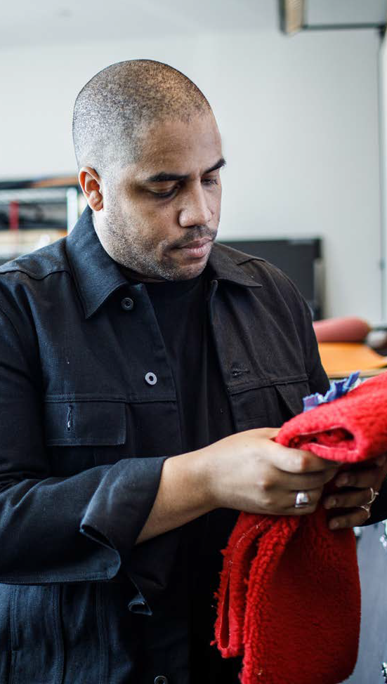 a person holds and looks at a red garment