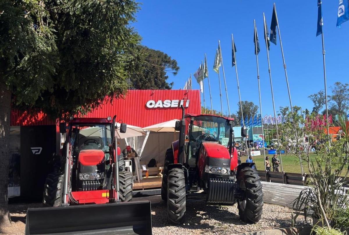 Two farming machines in front of a small Case IH building.