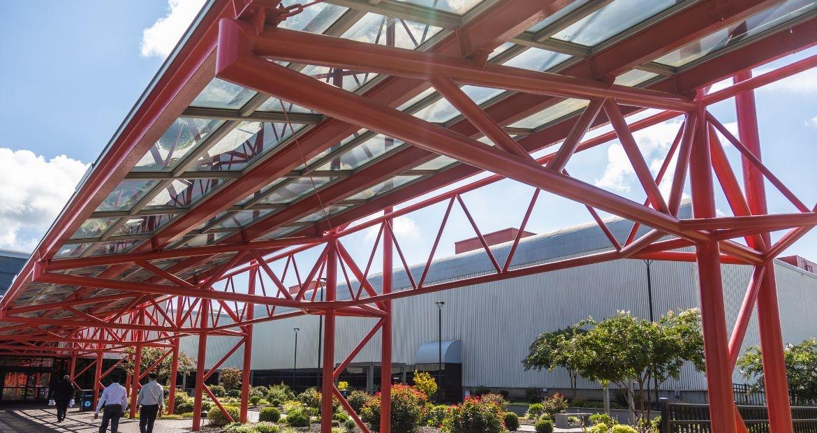 Exterior red support beams covering a walkway.