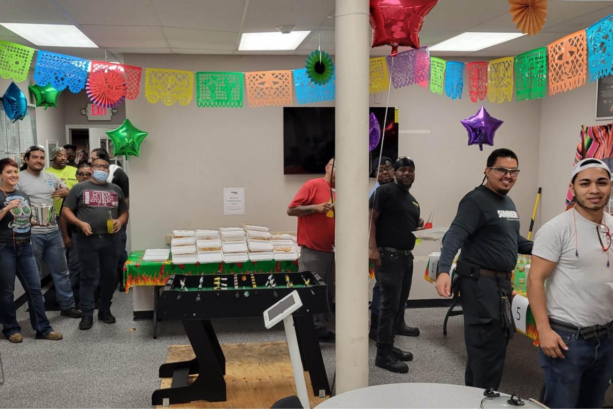 People in a line grabbing packaged food in a decorated room