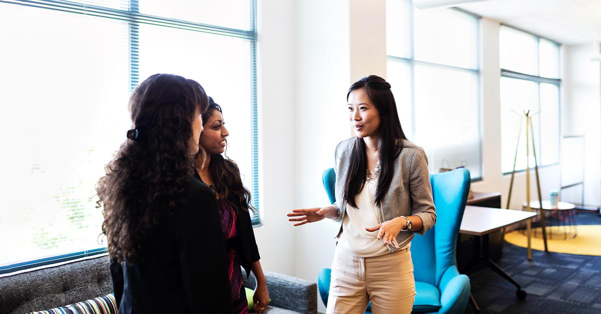 Three people talking together in an office setting