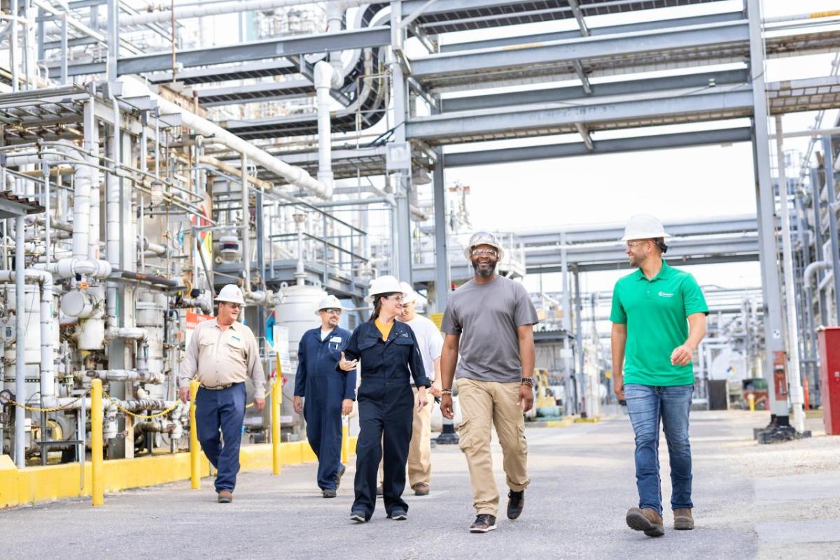 People in hardhats walking through a plant