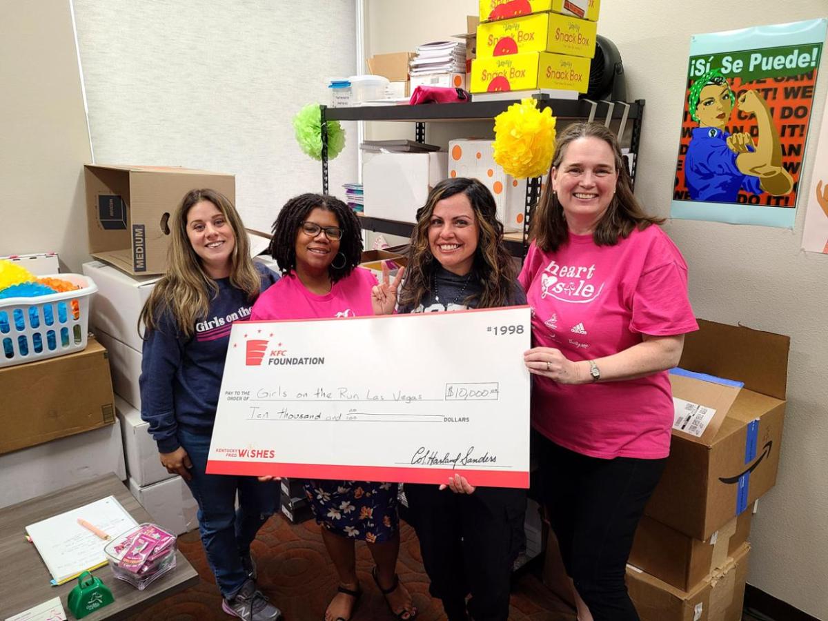 A group posed with a large check