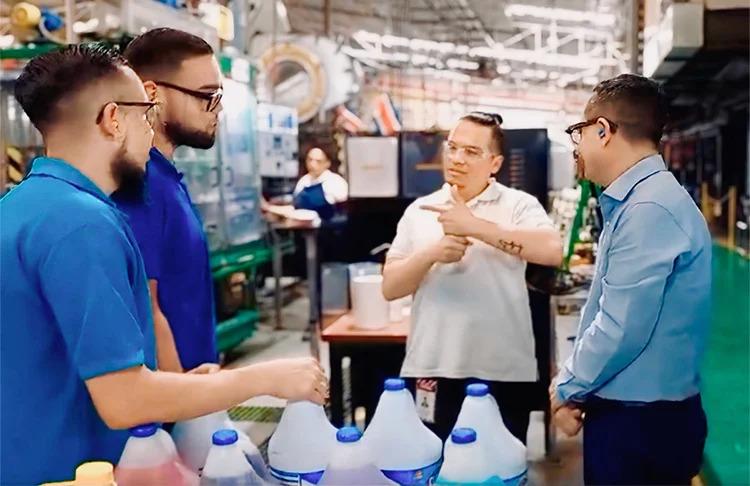 Jorge speaking with sign language to three other employees.