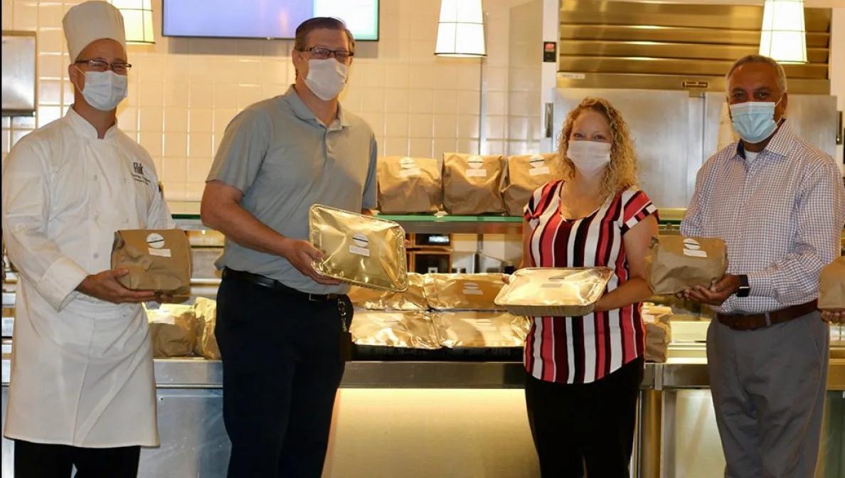 people holding packaged meals