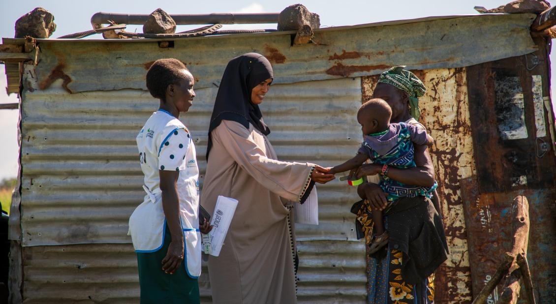 Action Against Hunger health workers greet a grandmother and her grandchild in Kenya. // Photo by Abel Gichuru