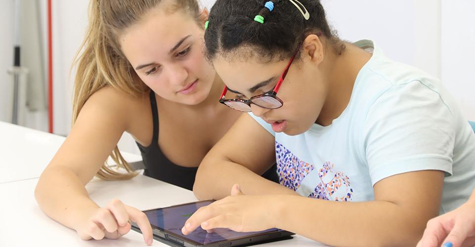 A person using a table with another assisting them