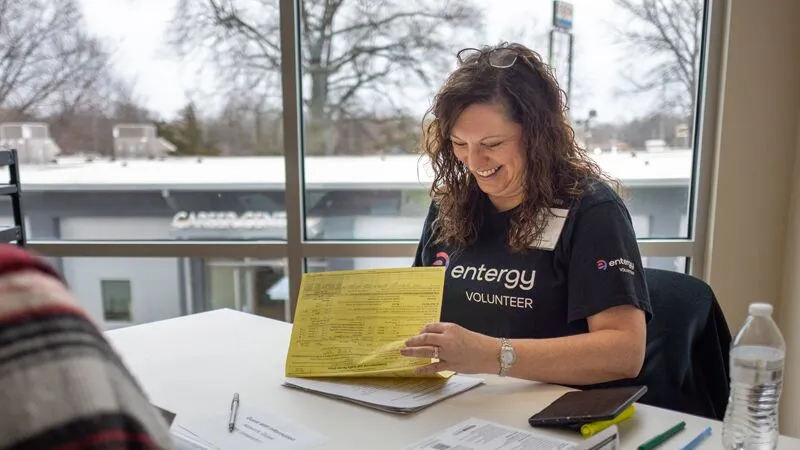 An Entergy volunteer smiling while helping a customer