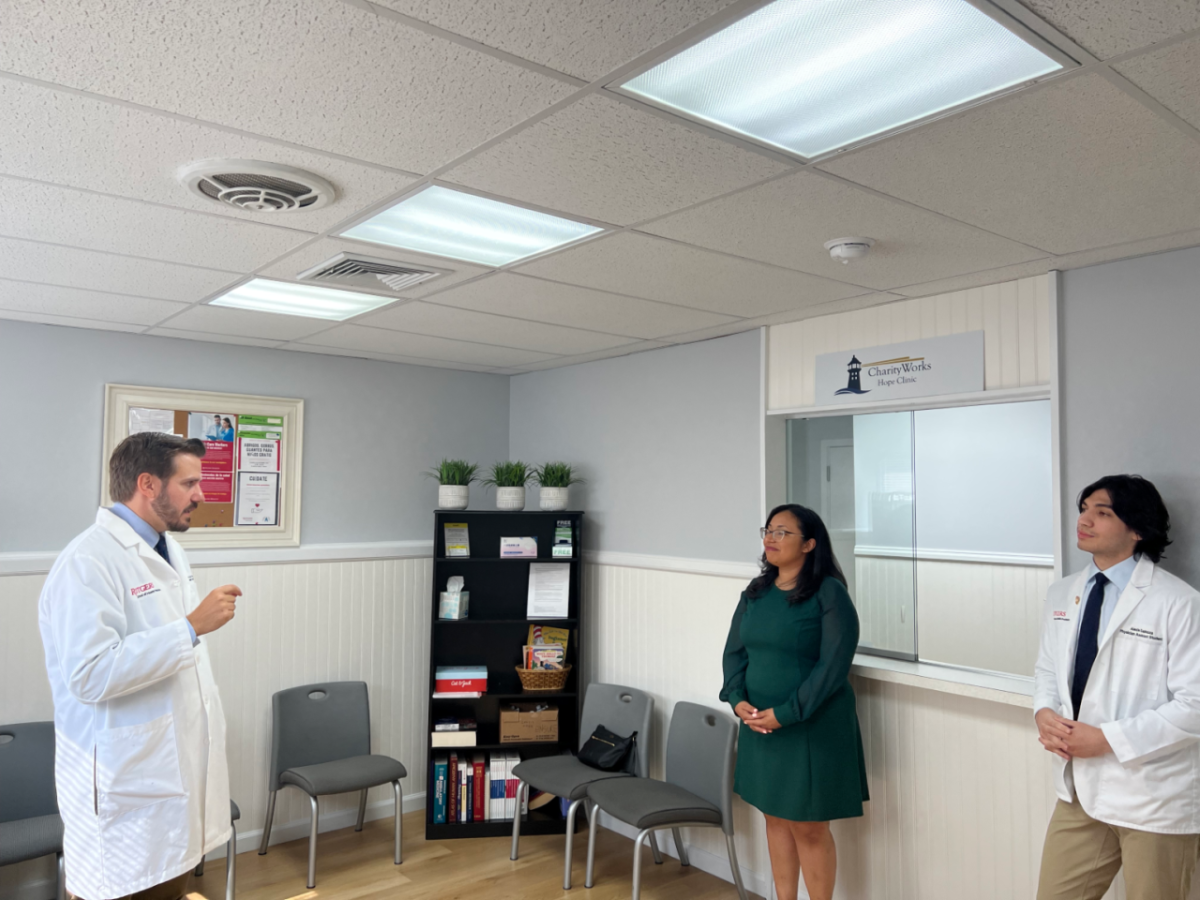 A doctor speaking to two others in the reception room of HOPE clinic.