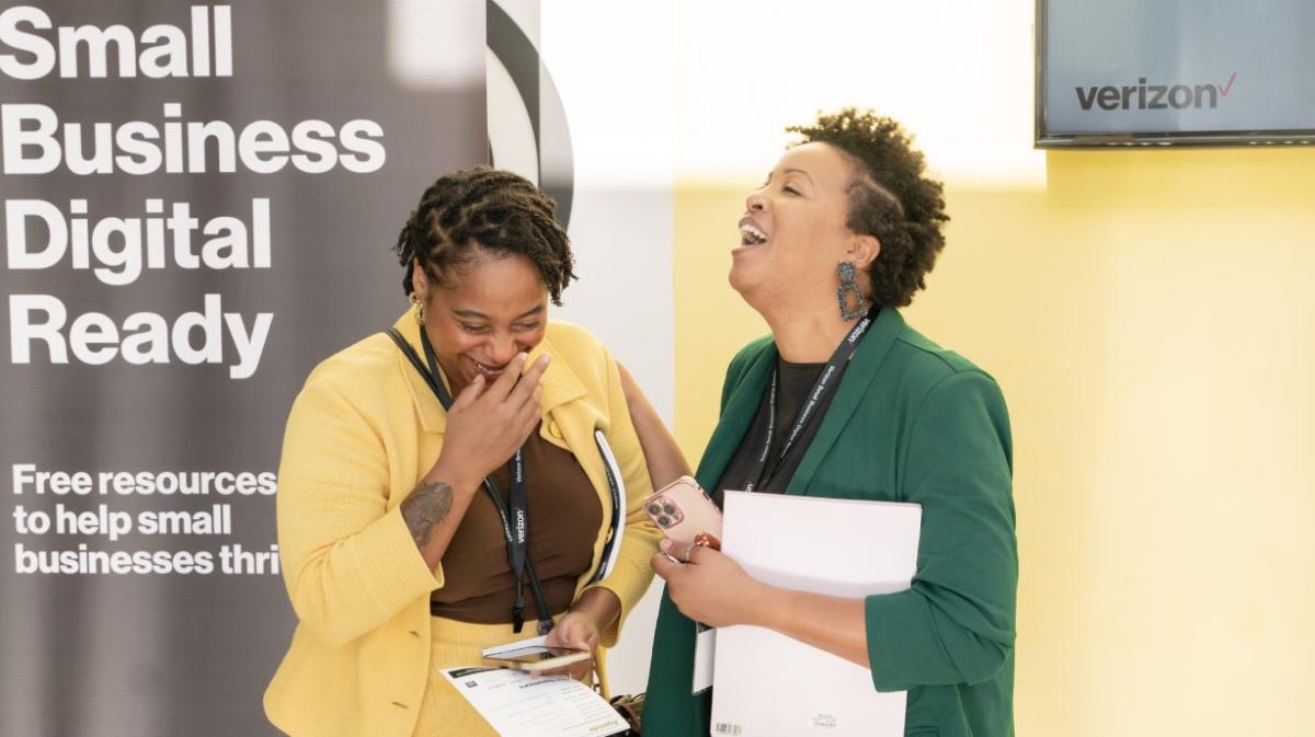 "Small Business Digital Ready" Two people laughing, holding papers.