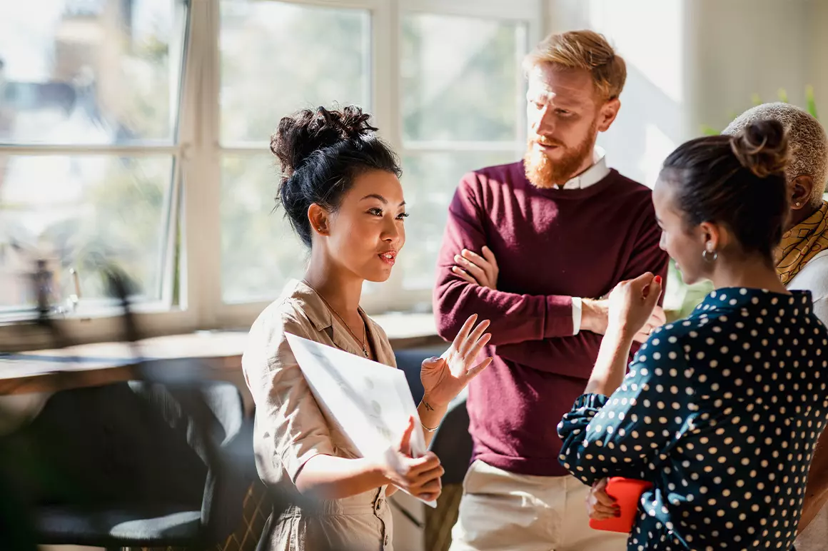 3 people talking in an office setting