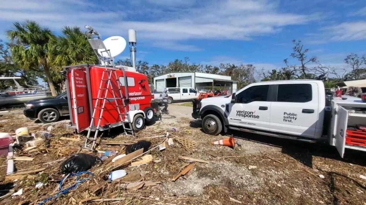 Verizon Response vehicle and trailer parked in an area of high debris and damaged buildings.