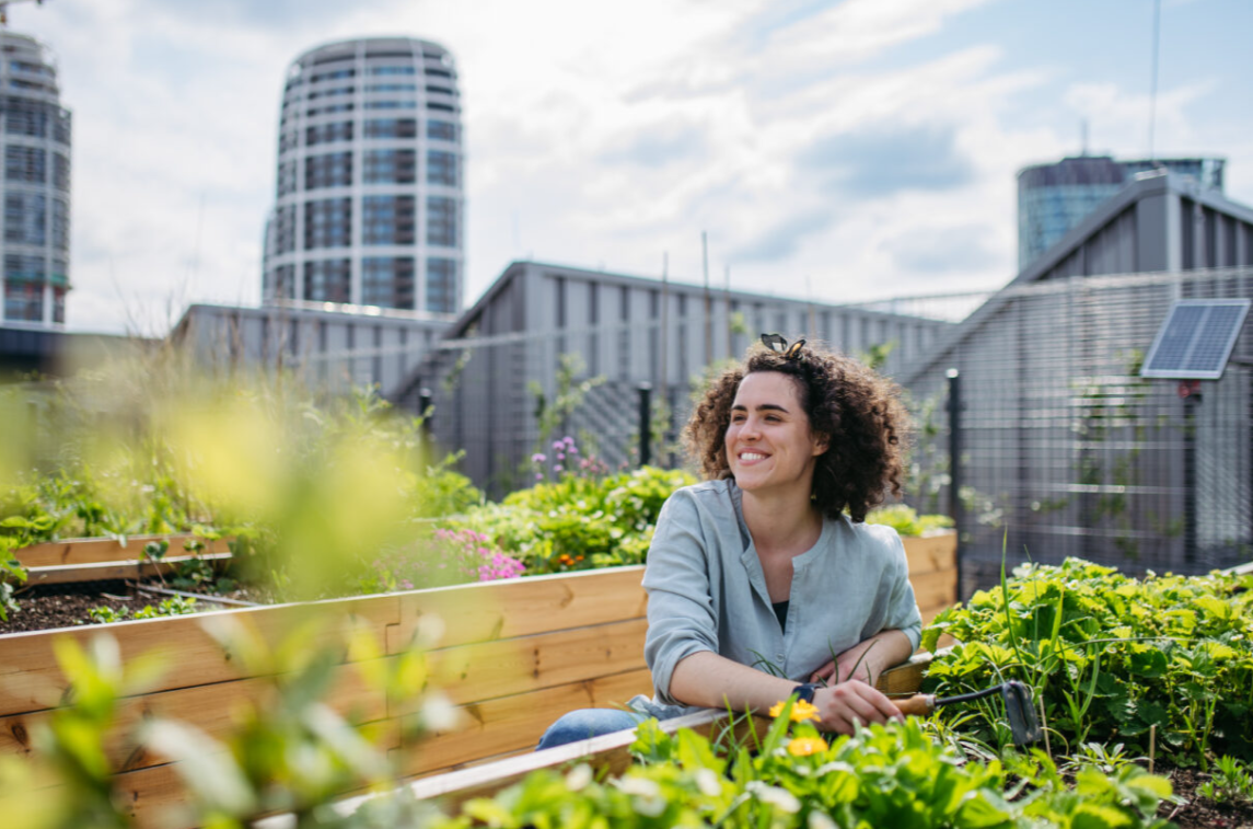 Woman smiling next to a garden bed