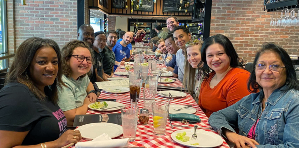 a group of about a dozen people sitting across from each other in a restaurant setting