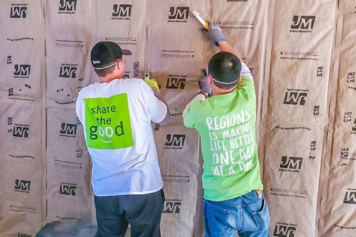 Two people install insulation 