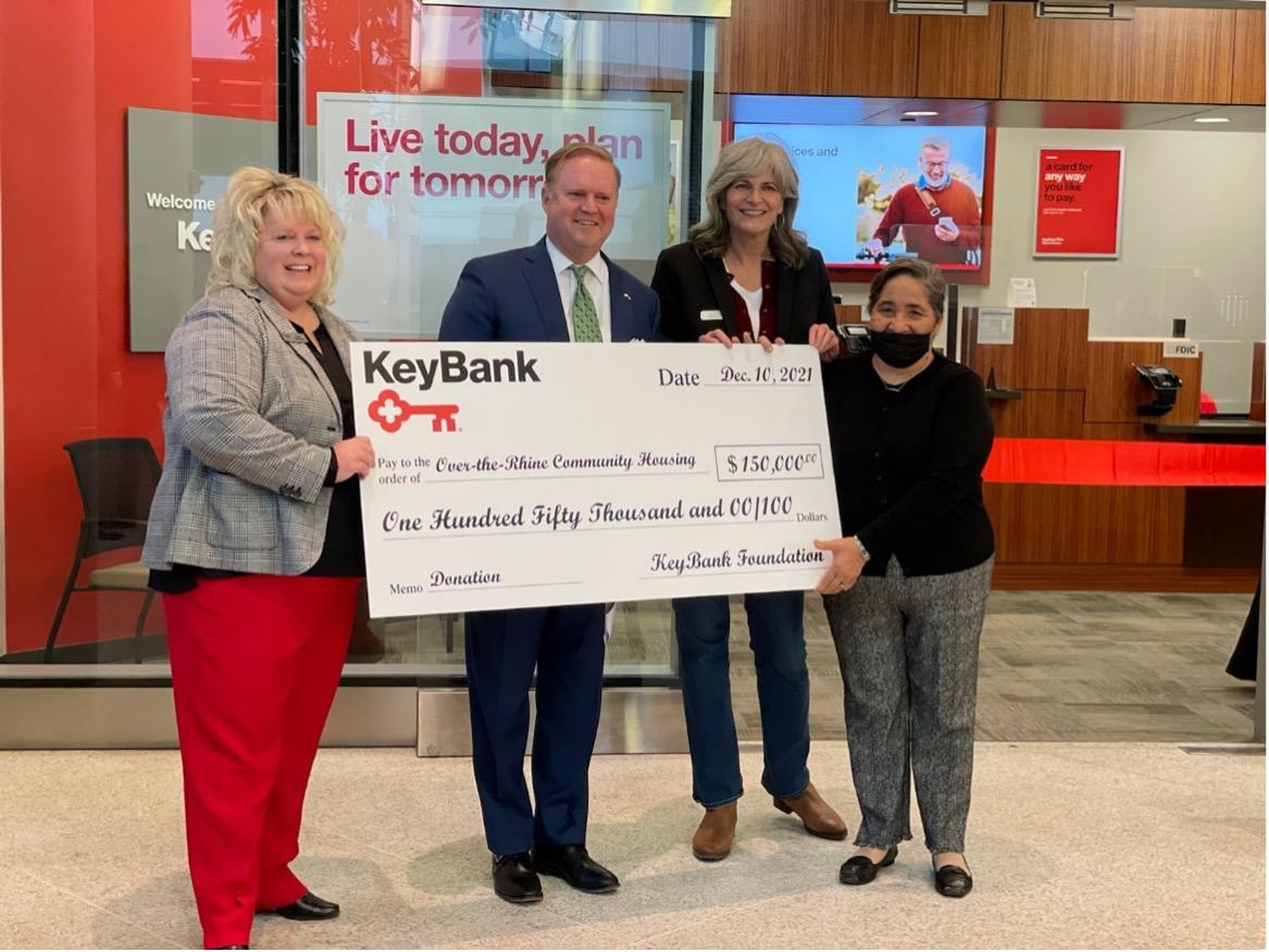 (From left) KeyBank Regional Retail Leader Stacy Radabaugh and Market President Michael McCuen present a KeyBank Foundation grant of $150,000 to Over-The-Rhine Community Housing Executive Director Mary Burke Rivers and OTRCH Board Vice President Georgia Keith. Group is holding a large KeyBank check for $150,000.